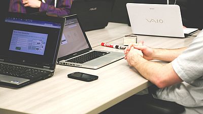 3 Personen mit Laptops am Tisch