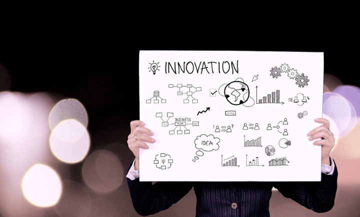 Eine Person hält ein Schild noch auf dem Innovation steht