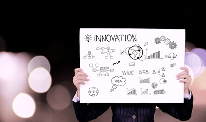 Eine Person hält ein Schild noch auf dem Innovation steht