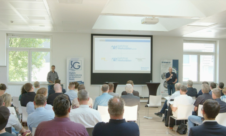mittelstand-digital-zentrum-wertnetzwerke-digitaltag-iserlohn-5G-blog Zwei Redner vor vielen Menschen in einem Saal