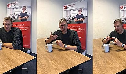 Niklas Kuhnert sitzt am Tisch und beantwortet Fragen
