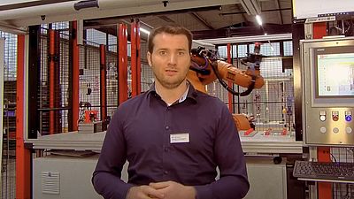 Mann erklärt Roboter im Hintergrund