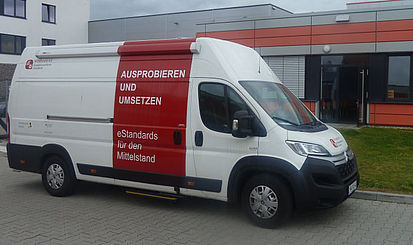 Mobile Werkstatt vor grau-rotem Gebäude