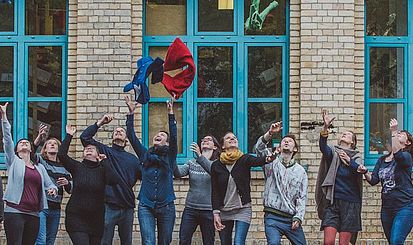 Eine Gruppe Menschen wirft Kleidung in die Luft