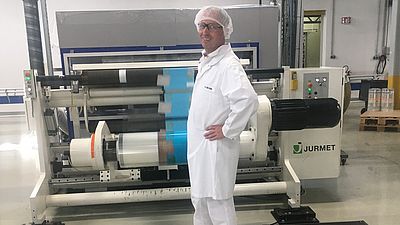 Mann im weißen Overall vor Maschine