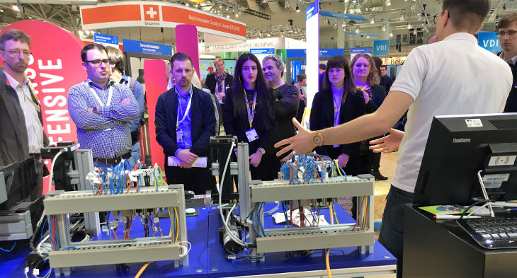 Unternehmerreise HMI:Technik vor Ort erleben Mann im weißen Hemd erklärt Technik vor Publikum