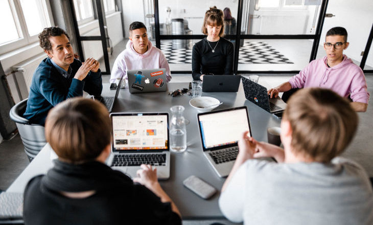 4 Menschen mit Laptops am Tisch